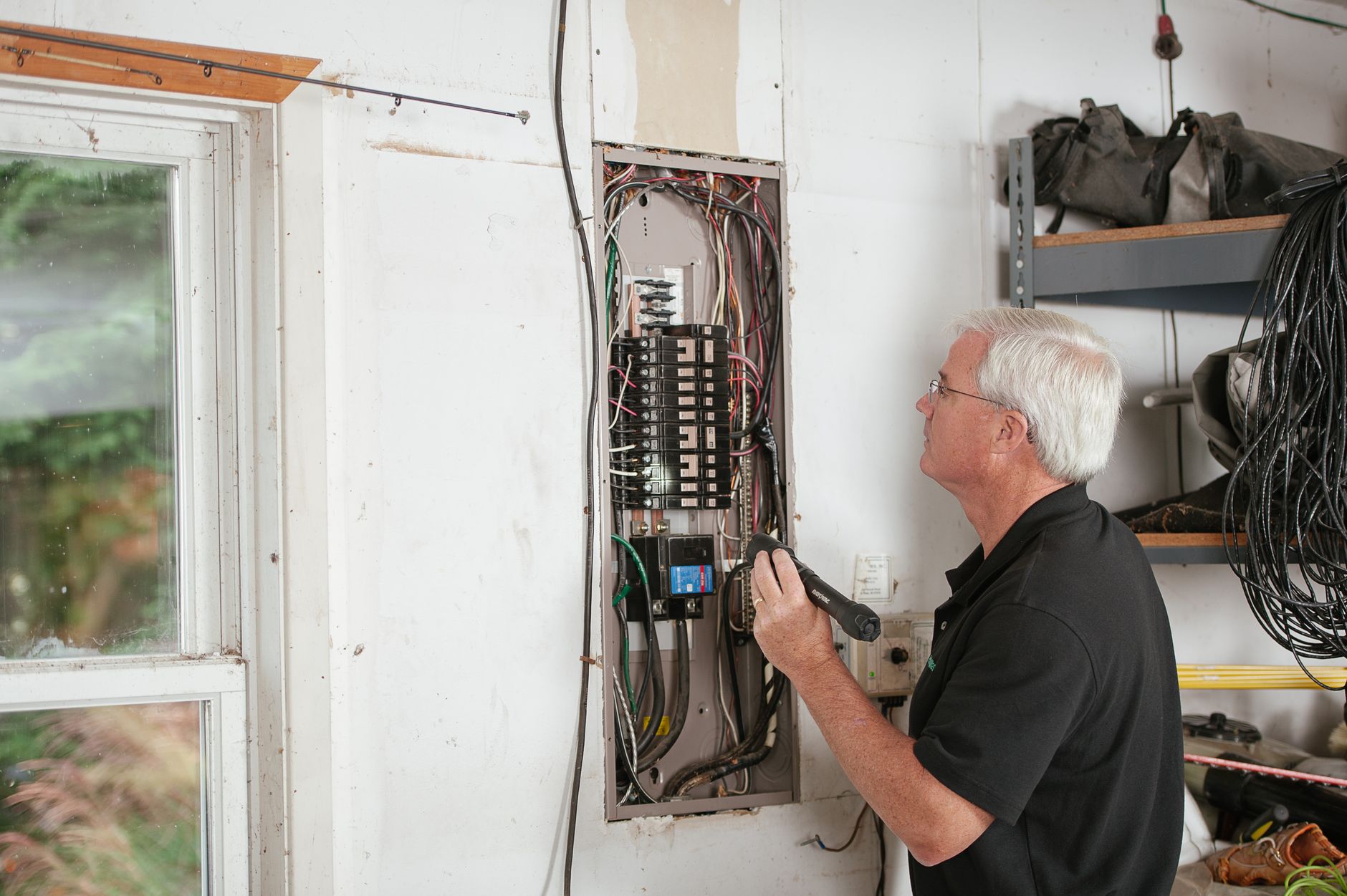 Electrician working inside an open residential breaker panel